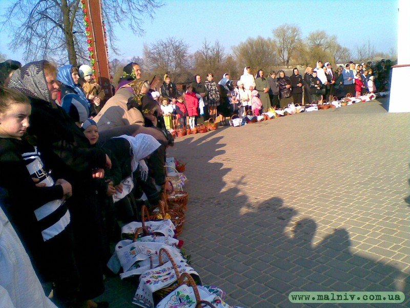 Люди вистроїлись з кошиками і пасками довкола церкви